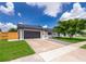 Charming single-story home featuring a gray-tone garage, solar panels, a sidewalk, and well-maintained landscaping at 12104 Shallot St, Orlando, FL 32837