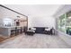Bright open-concept living room leading into the kitchen, featuring light tile floors and a sleek gray-tone sofa at 12104 Shallot St, Orlando, FL 32837