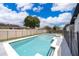 Sparkling in-ground pool with fenced yard and blue skies, perfect for summer days at 12104 Shallot St, Orlando, FL 32837