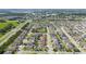 Aerial view of a well-planned neighborhood with neatly arranged homes and green spaces; house marked with red icon at 1703 Leatherback Ln, St Cloud, FL 34771