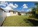 Private backyard with a lush lawn, complemented by a white fence that enhances the serene outdoor space at 1703 Leatherback Ln, St Cloud, FL 34771