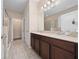 Bathroom featuring double sinks, wood cabinets, and a separate shower and closet area at 1703 Leatherback Ln, St Cloud, FL 34771