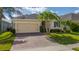 Lovely single-story home boasts a two car garage, brick driveway, and lush landscaping at 1703 Leatherback Ln, St Cloud, FL 34771