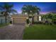 Charming single-story home with a brick driveway, well-maintained lawn, and beautiful palm tree at 1703 Leatherback Ln, St Cloud, FL 34771