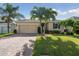 Beautiful single-story home featuring a well-kept lawn, brick driveway and mature palm trees at 1703 Leatherback Ln, St Cloud, FL 34771