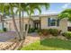 Charming single-story home with a well-manicured lawn, palm trees, and stone accents at 1703 Leatherback Ln, St Cloud, FL 34771