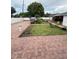 A brick paved backyard with a small grassy area, a bird bath, and a grill at 2013 Marilyn Ave, Winter Haven, FL 33881