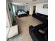 Inviting living room and bedroom featuring black sofas, a comfortable bed, and a bright patio entrance at 2013 Marilyn Ave, Winter Haven, FL 33881