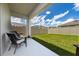 Cozy covered patio with chairs overlooking a lush, fenced backyard perfect for outdoor relaxation at 2211 Tay Wes Dr, St Cloud, FL 34771