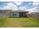 Large fenced backyard with a covered patio, offering plenty of space for outdoor activities and relaxation at 2211 Tay Wes Dr, St Cloud, FL 34771