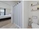 Clean bathroom showcasing a shower with curtain, toilet, and neat storage shelves at 2211 Tay Wes Dr, St Cloud, FL 34771
