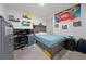 Modern bedroom featuring a bed, desk with computers, and bright artwork, creating a vibrant and functional space at 2211 Tay Wes Dr, St Cloud, FL 34771