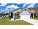 Attractive home exterior with lush front yard, concrete driveway, and two-car garage at 2211 Tay Wes Dr, St Cloud, FL 34771
