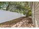 Backyard featuring a brick paver pathway, white vinyl fence, and mature landscaping at 2343 St George Dr, Davenport, FL 33837
