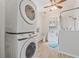Updated bathroom features a vanity, a stacked washer-dryer, shower stall with glass at 2343 St George Dr, Davenport, FL 33837
