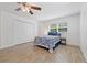 Bright bedroom features wood-look tile flooring, ceiling fan, closet, and updated fixtures at 2343 St George Dr, Davenport, FL 33837