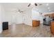 Open-concept living room with wood-look floors, ceiling fan, neutral walls, and views to the kitchen and entry at 2343 St George Dr, Davenport, FL 33837