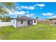 Expansive backyard featuring lush green grass and a screened-in patio attached to a modern home at 2668 Coachman Dr, Deltona, FL 32738