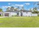 Well-manicured lawn and landscaped garden beds accent this charming, white single-story home at 2668 Coachman Dr, Deltona, FL 32738
