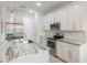 Bright kitchen featuring stainless steel appliances, white cabinetry, granite counters and a kitchen island at 2668 Coachman Dr, Deltona, FL 32738