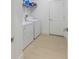 Functional laundry room with white washer and dryer, overhead shelving, and neutral flooring at 2668 Coachman Dr, Deltona, FL 32738