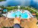 Overhead view showcasing the elaborate pool design with palm trees and surrounding lounge chairs and seating areas at 2698 Chantilly Ave, Kissimmee, FL 34741