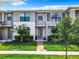 Modern townhome featuring a brick walkway, lush landscaping, and neutral exterior paint at 2698 Chantilly Ave, Kissimmee, FL 34741