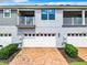 Well-maintained townhome featuring a two-car garage, brick driveway, and manicured landscaping at 2698 Chantilly Ave, Kissimmee, FL 34741