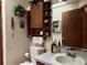 Compact bathroom featuring vanity, toilet, and decorative shelving with plants and accessories at 2700 Cherokee Rd, St Cloud, FL 34772