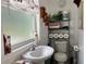 Cozy bathroom with sink, toilet, storage shelves and a window letting in light at 2700 Cherokee Rd, St Cloud, FL 34772