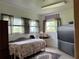 Bedroom showcasing three windows, a twin bed, TV, and comfortable flooring at 2700 Cherokee Rd, St Cloud, FL 34772