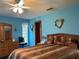 Bedroom featuring a ceiling fan, dresser, window, and large comfortable bed at 2700 Cherokee Rd, St Cloud, FL 34772