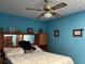 Bedroom featuring a ceiling fan, a full size bed, and blue walls with decor at 2700 Cherokee Rd, St Cloud, FL 34772
