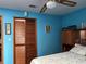 Bedroom features a ceiling fan, a full size bed, and blue walls with decor at 2700 Cherokee Rd, St Cloud, FL 34772