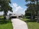 Spacious home features mature trees, a well-manicured lawn, an attached two-car garage, and a long driveway at 2700 Cherokee Rd, St Cloud, FL 34772