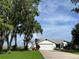 Inviting home exterior framed by mature trees, featuring a well-manicured lawn and an outbuilding at 2700 Cherokee Rd, St Cloud, FL 34772