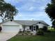 Lovely home featuring a well-manicured lawn, mature trees, an attached two-car garage, and beautiful flower beds at 2700 Cherokee Rd, St Cloud, FL 34772