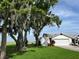 Charming single-story home features a well-manicured lawn, mature trees with Spanish moss, and an attached two-car garage at 2700 Cherokee Rd, St Cloud, FL 34772