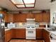 Functional kitchen with wooden cabinets, skylight and a suite of white appliances, offering both style and practicality at 2700 Cherokee Rd, St Cloud, FL 34772