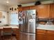 Cozy kitchen features wood cabinets, stainless refrigerator, and workspace near the window at 2700 Cherokee Rd, St Cloud, FL 34772