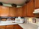 Kitchen area features wooden cabinets, mosaic backsplash, and countertop microwave at 2700 Cherokee Rd, St Cloud, FL 34772