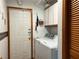 Laundry room with modern washer and dryer, white cabinets, and access to the outside at 2700 Cherokee Rd, St Cloud, FL 34772