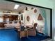 Bright living room open to the kitchen, featuring blue carpet and vaulted ceilings at 2700 Cherokee Rd, St Cloud, FL 34772