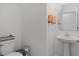 Contemporary half bathroom with a toilet, pedestal sink, decorative towels, and modern fixtures at 2759 Slash Way, St Cloud, FL 34771