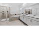 Modern bathroom featuring double vanity, soaking tub, and a separate glass-enclosed shower at 2759 Slash Way, St Cloud, FL 34771