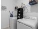 Well-organized laundry room featuring a washer, dryer, shelving, and ironing board at 2759 Slash Way, St Cloud, FL 34771