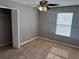 This bedroom features neutral walls, carpet flooring, ceiling fan, and window for natural light at 2940 Tanzanite Ter, Kissimmee, FL 34758