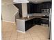Bright kitchen featuring granite counters, dark cabinets, stainless appliances, and tile floors at 2940 Tanzanite Ter, Kissimmee, FL 34758