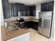 Modern kitchen with dark wood cabinets, granite countertops, stainless steel appliances, and tile floors at 2940 Tanzanite Ter, Kissimmee, FL 34758
