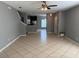 Open-concept living room featuring stairs, gray walls, ceiling fan, and tan tile floors throughout at 2940 Tanzanite Ter, Kissimmee, FL 34758